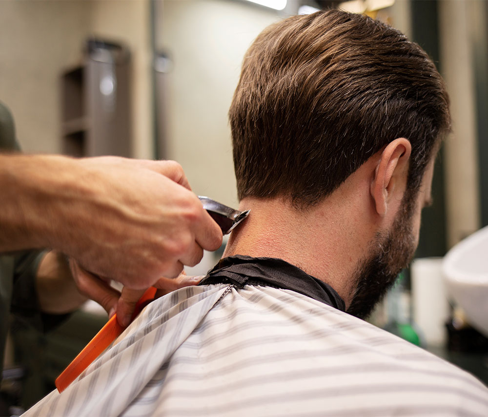 man getting the hair on his neck trimmed